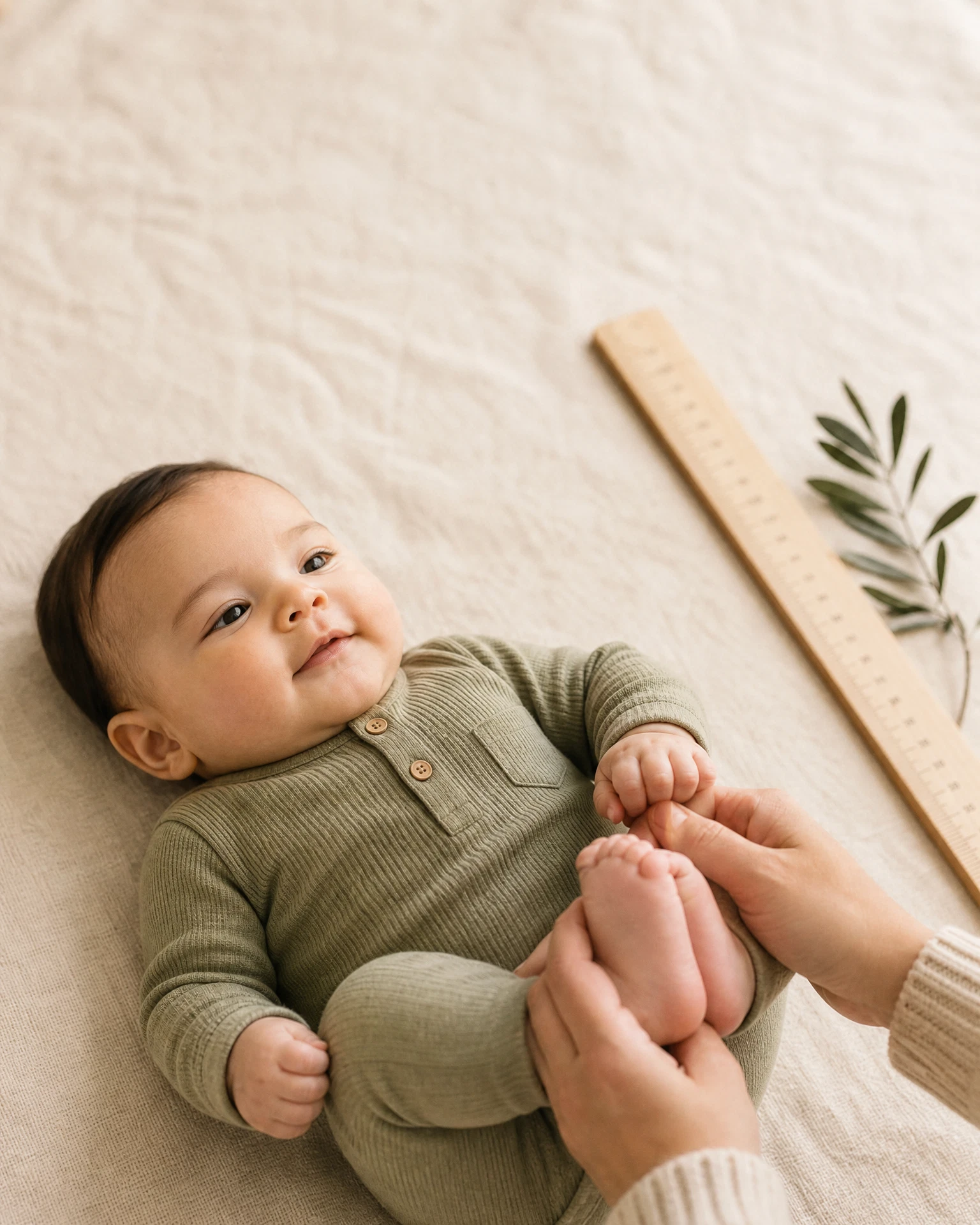 Caregiver gently holding an infant's feet during a growth-focused moment